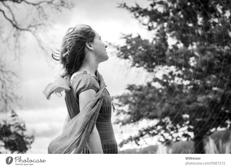 A young girl enjoys the wind fluttering hair and scarf Wind windy Nature out Girl Young woman teenager To enjoy Air squall stormy wind force Judder Blow Sky