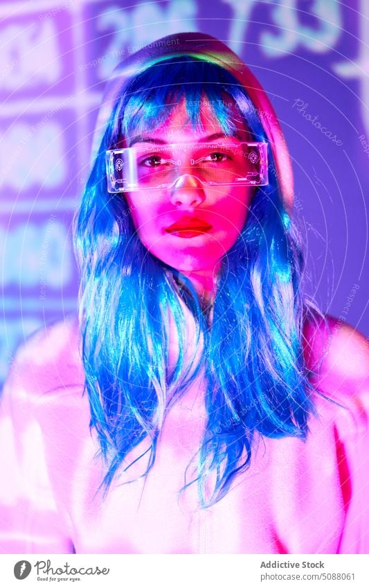 Futuristic woman with transparent goggles and virtual screen model innovation hi tech cyber portrait device illuminate neon future concentrate female red lips