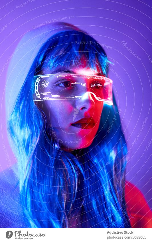 Futuristic woman with transparent goggles and virtual screen model innovation hi tech cyber portrait device illuminate neon future concentrate female red lips