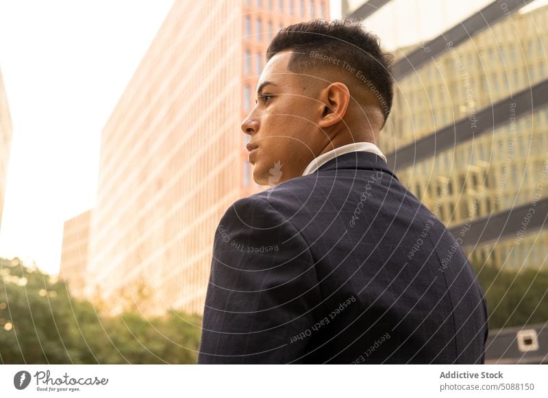 Confident businessman standing against modern buildings confident respectable professional entrepreneur contemporary self assured city center think contemplate