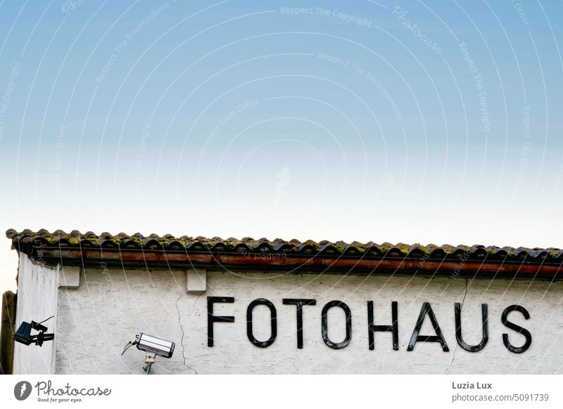 Photo house - lettering and video surveillance in front of half blue sky Photo House Architecture architectonically Architecture and buildings Lettering