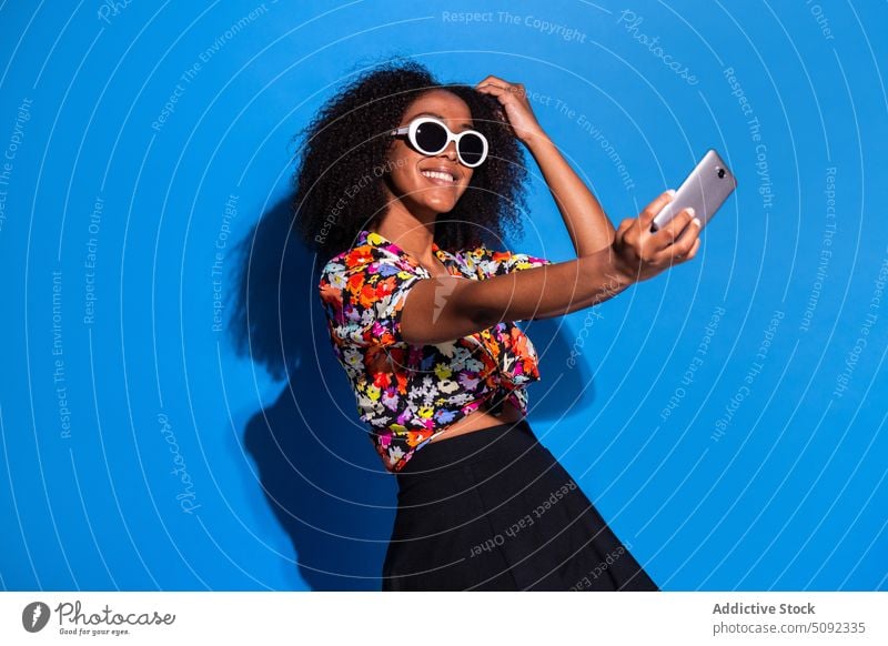 Stylish African American female taking selfie woman smile style smartphone adjust sunglasses happy colorful bright young black african american ethnic modern