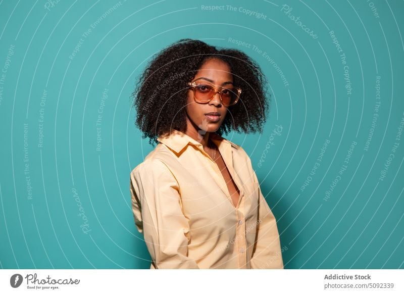 Stylish black model in shirt and sunglasses woman style appearance curly hair serious portrait colorful bright female african american ethnic young