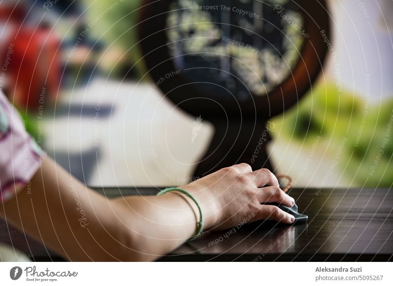 A child or teenager is playing computer video games on a large screen. Online video game technology and teen gaming addiction. Close-up child's hand with mouse