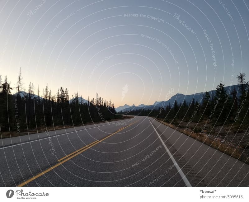 alone on the highway Street Trans-Canada Highway Lane markings Mountain Sunrise Twilight Sky Landscape Tourism Vacation & Travel Alberta route forsake sb./sth.