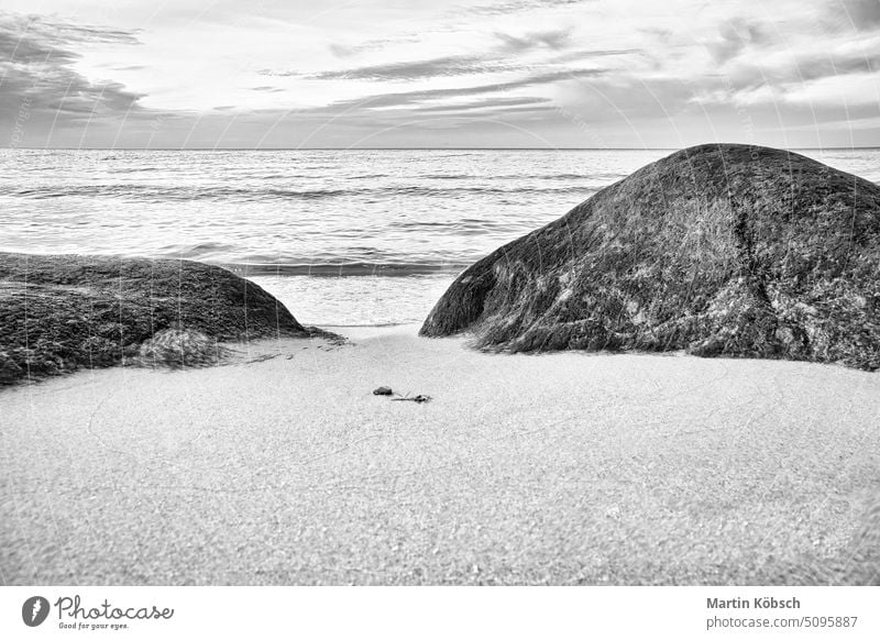 Big stone on the sandy beach in front of the sea with clouds in the sky. Scandinavia Stone coast nobody still life stone beach Baltic Sea ocean