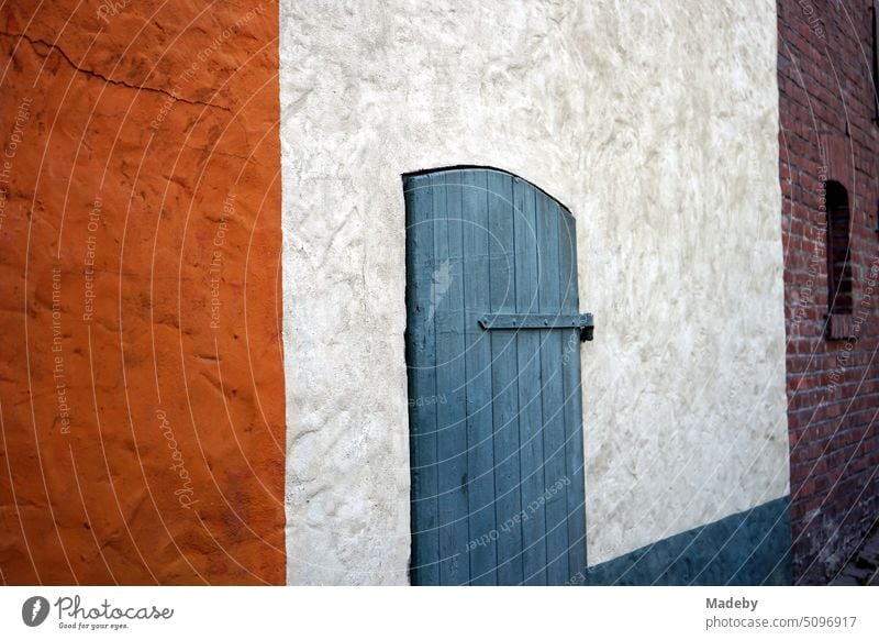 Old blue wooden door in an old white painted facade in Weinberggasse in the old town of Blomberg in Ostwestfalen-Lippe, Germany Wall (building) Window