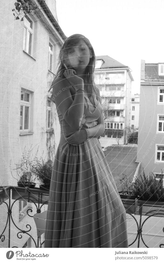 Woman in evening dress smoking on balcony in black white pretty Lifestyle portrait long hairs jungles Smoking Evening dress Blonde black-white Balcony Smoke