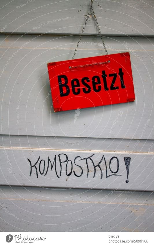 closed door of a composting toilet with a red busy sign Composting toilet notdurft john Eco-friendly occupied Sustainability human excrements Ecological