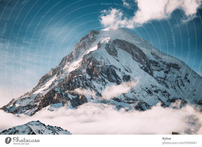 Georgia. Peak Of Mount Kazbek Covered With Snow. Kazbek Is A Stratovolcano And One Of Major Mountains Of Caucasus. Beautiful Georgian Nature Landscape In Early Winter.