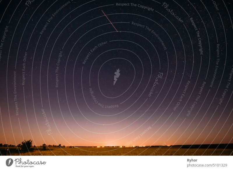 Natural Night Starry Sky Above Summer Field Meadow. Glowing Stars, Aircraft Light Trail And Sunset Sunrise Lights Above Meadow Landscape landscape shine summer