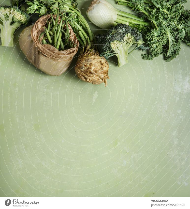 Various green vegetables: kale,broccoli, fennel, green beans, celery on green background, top view. Healthy food various healthy food overhead vitamin diet