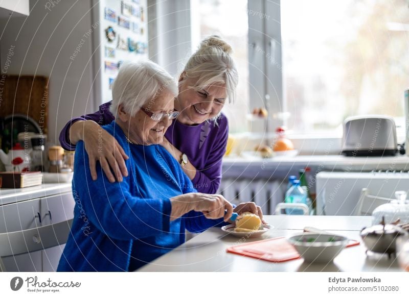 Woman spending time with her elderly mother at home smiling happy enjoying positive people woman senior mature female house old aging domestic life grandmother