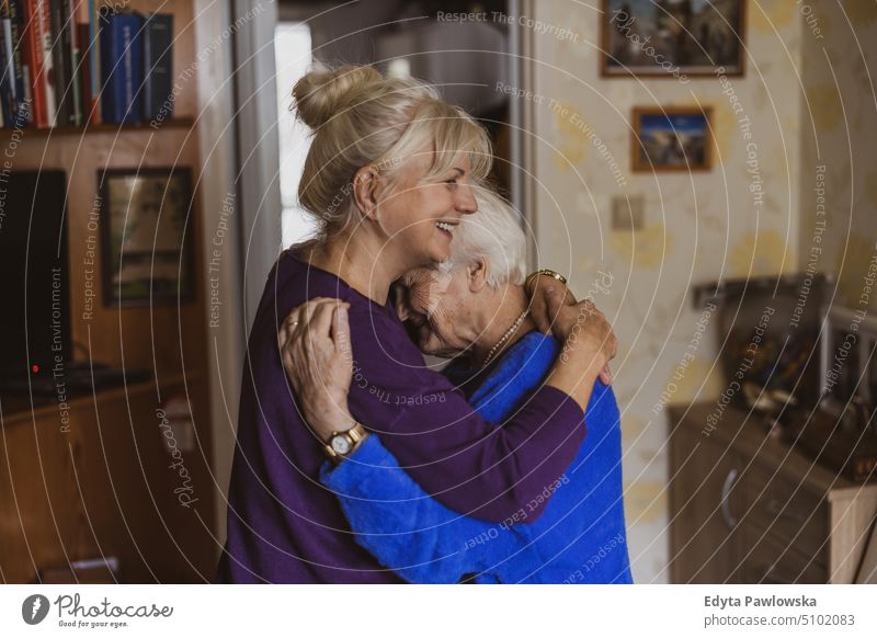 Woman hugging her elderly mother smiling happy enjoying positive people woman senior mature female home house old aging domestic life grandmother pensioner