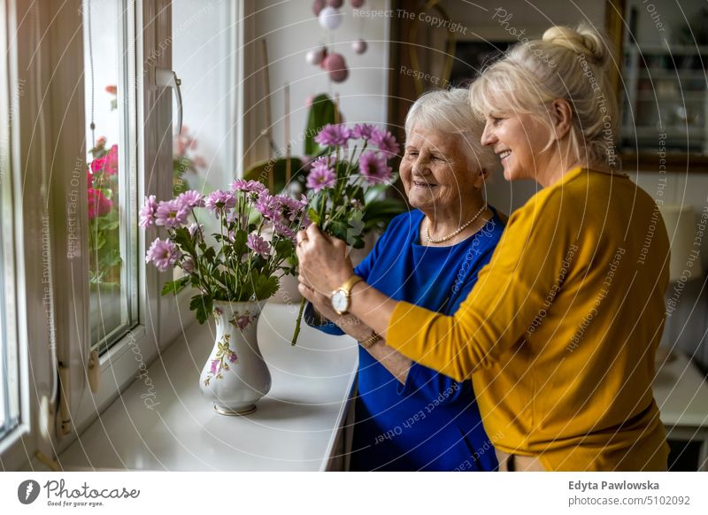 Woman spending time with her elderly mother at home smiling happy enjoying positive people woman senior mature female house old aging domestic life grandmother