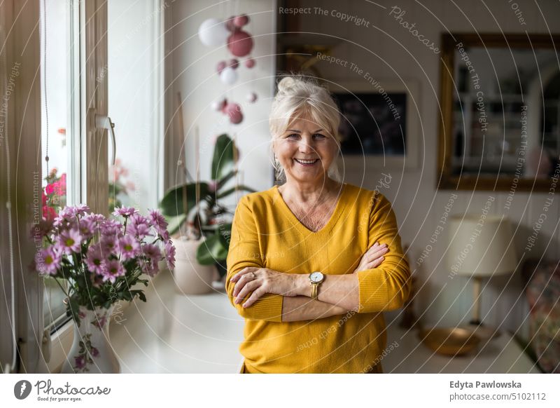 Portrait of a senior woman in her home smiling happy enjoying positive people mature female elderly house old aging domestic life grandmother pensioner retired