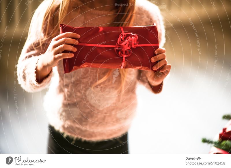 Child holds a gift in his hands at Christmas gifts Giving of gifts Joy christmas eve Infancy Tradition Happiness Girl Gift