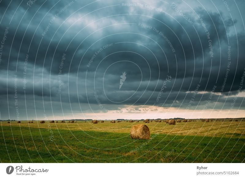 Dramatic Sky Before Rain With Rain Clouds On Horizon Above Rural Landscape Field Meadow With Hay Bales After Harvest yellow farming europe nobody summer nature