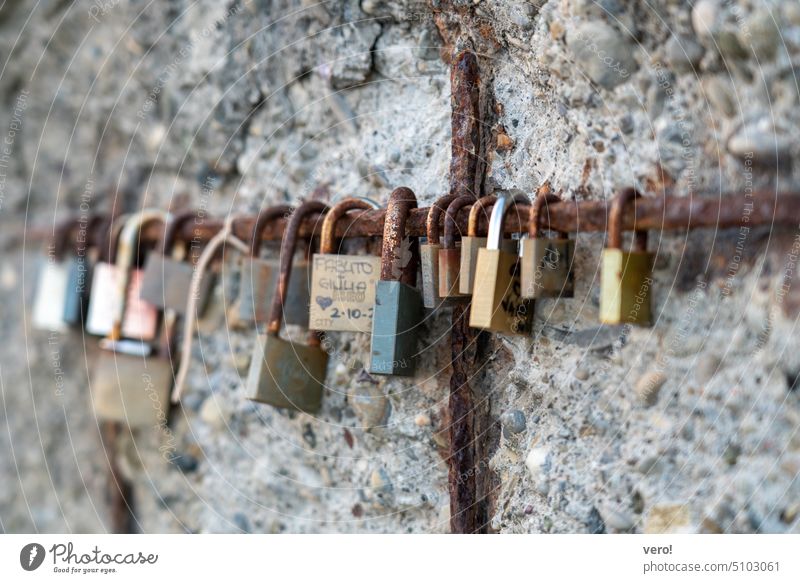 Love locks on iron bar on the old wall Sympathy With love Symbols and metaphors safety lock Relationship Declaration of love Kitsch Display of affection