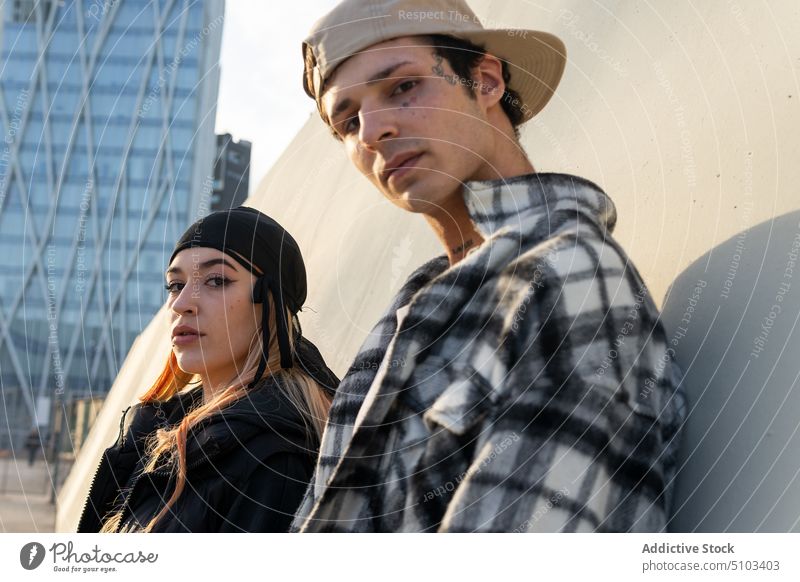 Confident stylish couple on street confident style urban together lean wall modern relationship boyfriend girlfriend young self assured outfit garment