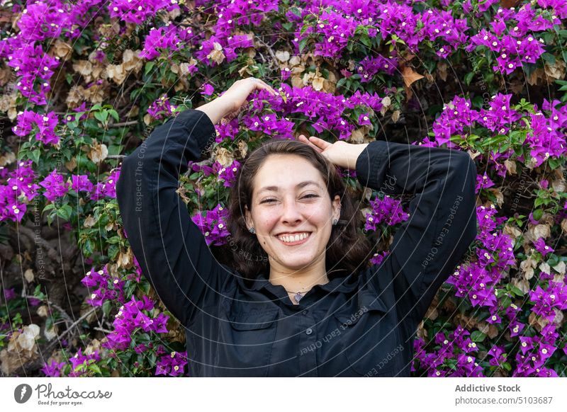 Smiling woman in blooming garden park countryside smile enjoy flower cheerful appearance chill idyllic rest female positive style lady leaf charming shrub