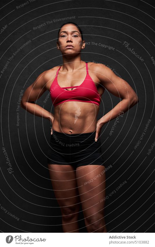 Muscular woman with hands on waist sportswoman hand on waist figure body wellbeing physical studio shot athlete fitness sporty latin hispanic ethnic shape