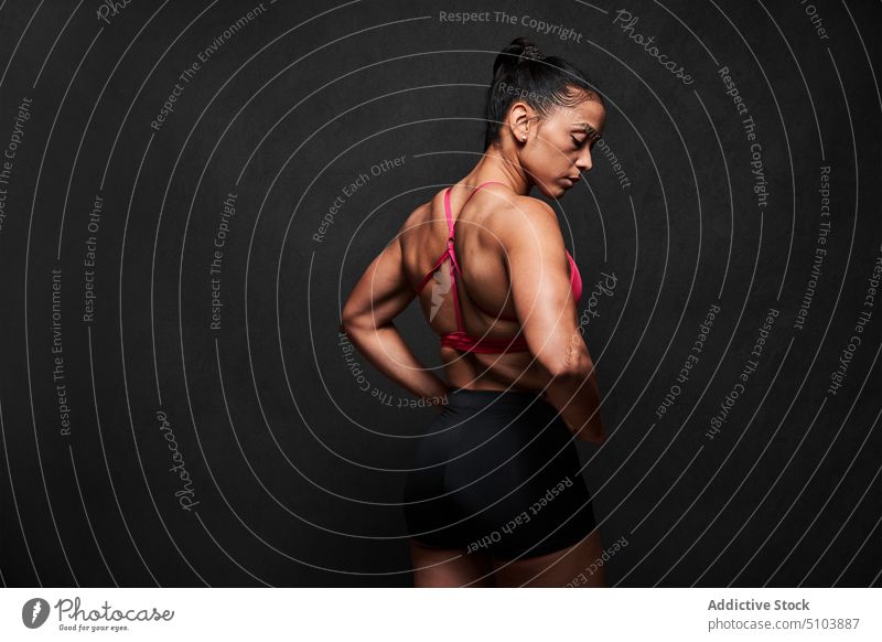 Muscular woman with hands on waist sportswoman hand on waist figure body wellbeing physical studio shot athlete fitness sporty latin hispanic ethnic shape