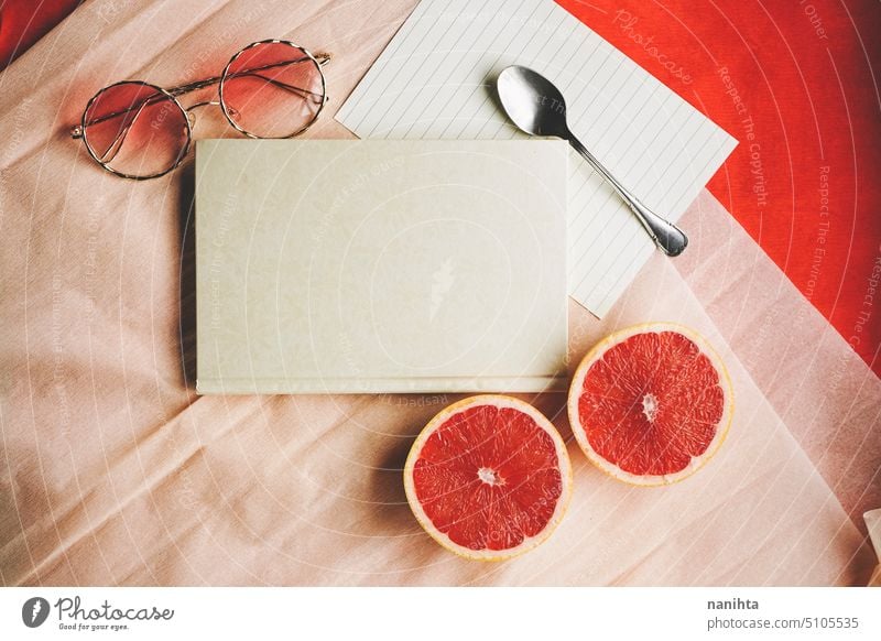 Flat lay background image with a elegant diary surrounded by common objects in vibrant colors flat lay mockup customice warm peach red design elegance