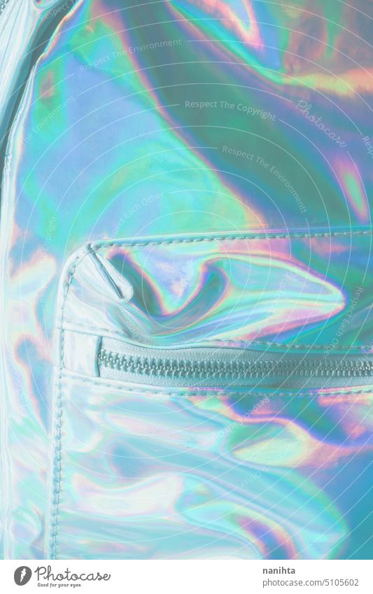 Detail of an holographic and iridiscent school bag rainbow background zipper pocket accessories fashion trendy fresh cool youth youthful punk aesthetic