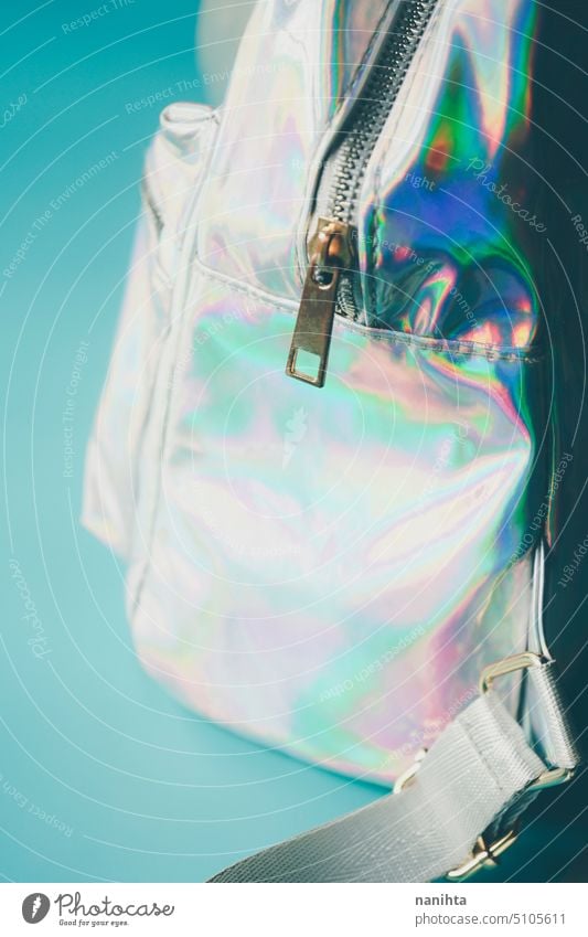 Detail of an holographic and iridiscent school bag rainbow background zipper pocket accessories fashion trendy fresh cool youth youthful punk aesthetic