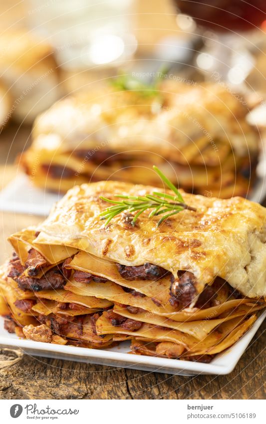 Close-up of a portion of lasagne Lasagne Basil Rustic Wood homemade Delicious Crockery Gourmet dressed Mozzarella bechamel Minced meat Restaurant Bolognaise