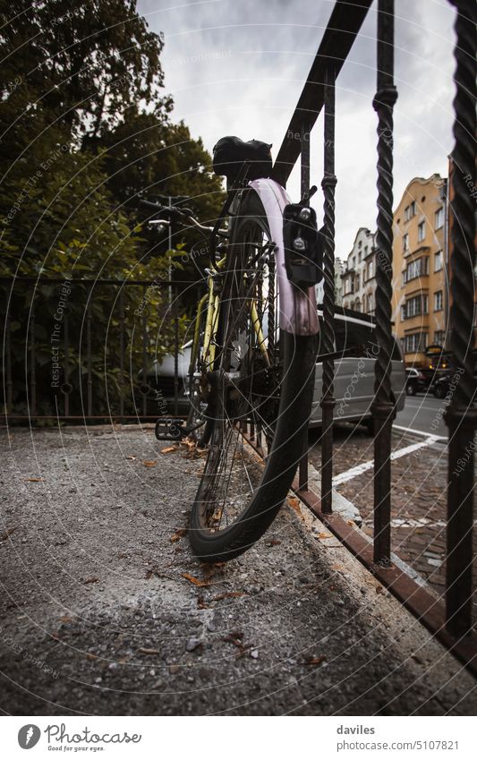 Abandoned bicycle in a fence, in the city of Innsbruck, Austria. abandoned austria bent bent wheel bike black broken damaged destroyed dirty europe frame