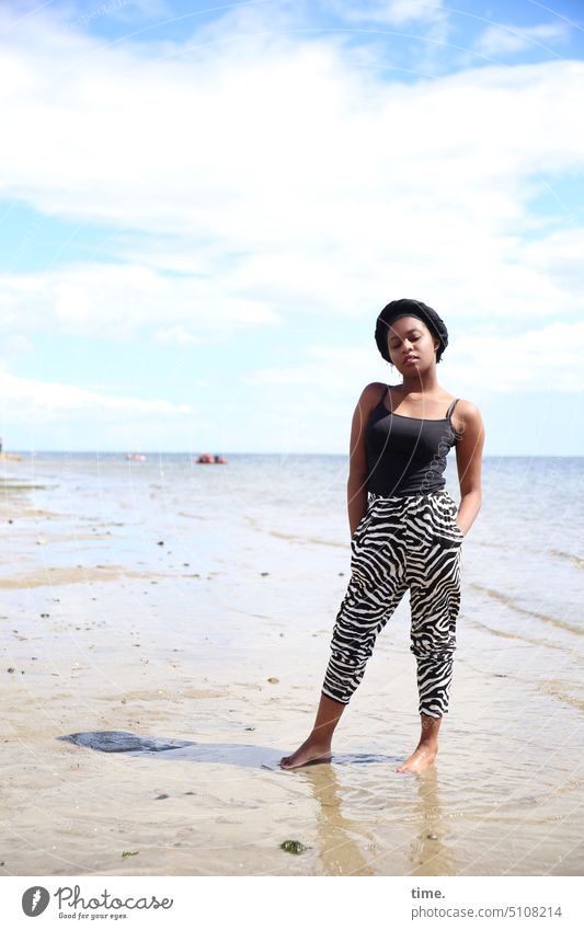 Woman on the beach of the Baltic Sea Beach Self-confident Water Ocean Summer Horizon Sky sunny Shadow Skeptical Moody Pride Feminine feminine Dark-haired Stand