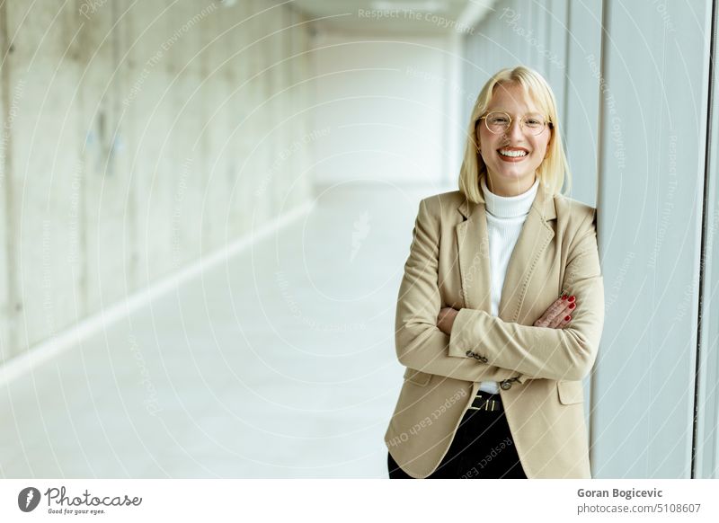 Business woman standing in the office corridor happy casual businesswoman female looking glasses happiness people workplace 1 caucasian blonde professional