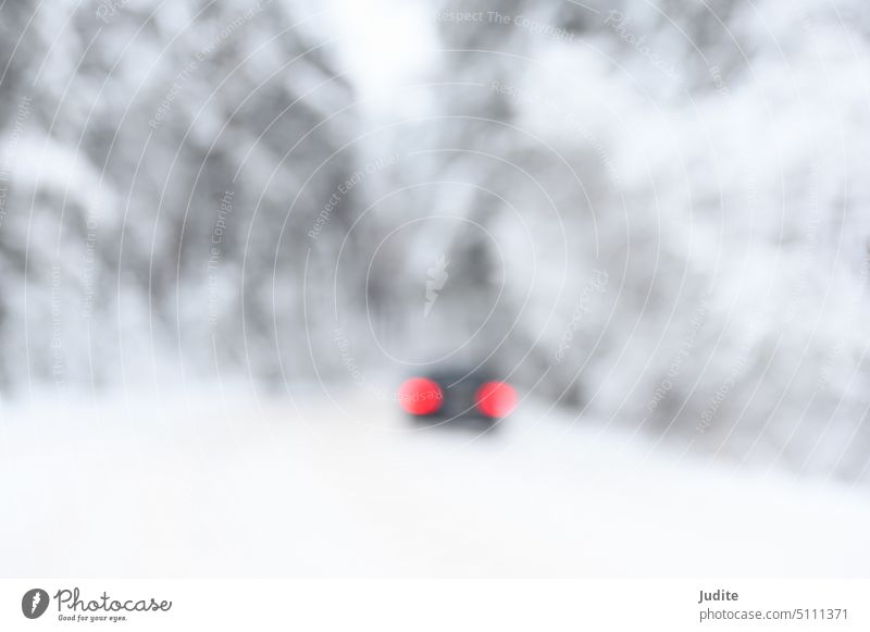 Blurred abstract snow covered trees in forest and red car tail lights on the road alley art backdrop background blur blurred bokeh bright business christmas