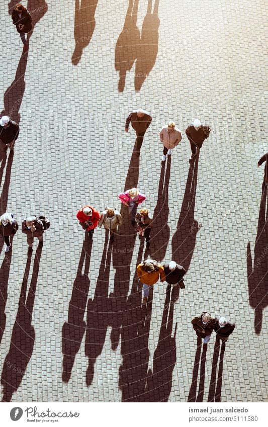 large group of people walking around the city, Bilbao city, basque country, spain crowd tourists tourism person human pedestrians shadow silhouette street