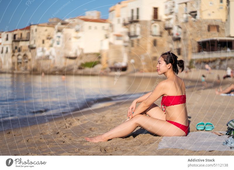 Asian woman resting on beach tourist weekend sea vacation resort summer sunbath holiday cefalu italy happy sicily female young asian ethnic bikini towel coast