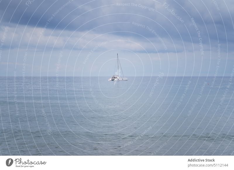 Sailboat in sea against cloudy sky sailboat float stormy gray marine water ripple weather ocean transport yacht vessel seascape gloomy dull nautical seaside