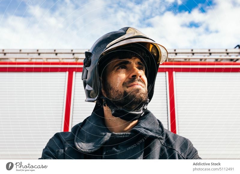 Hispanic male firefighter with helmet fireman fire engine station work uniform emergency portrait hispanic ethnic adult delight safety vehicle service staff