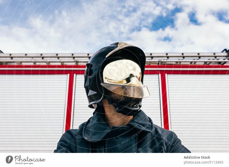 Confident fireman in uniform and helmet confident garage station work emergency professional portrait male self assured arms crossed hardhat firefighter worker