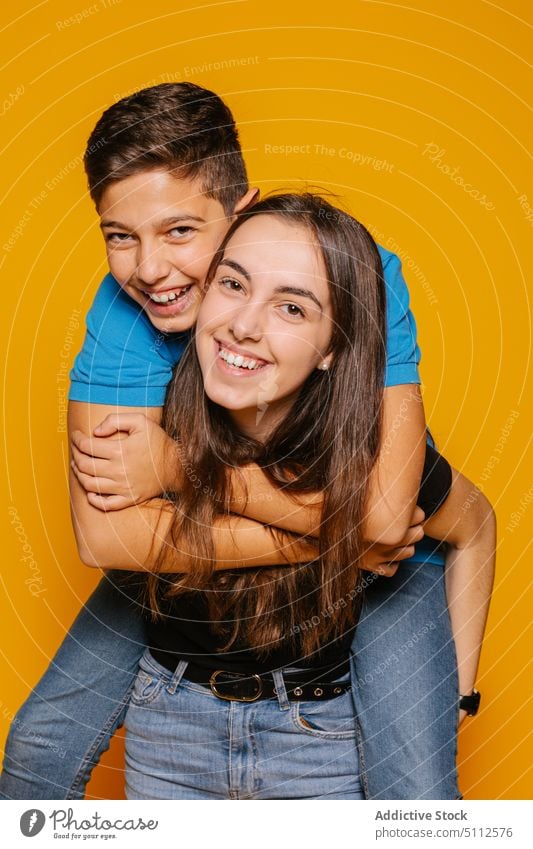 Happy couple hugging in studio happy cheerful smile joy positive together embrace piggyback glad love excited optimist girl casual laugh young bright