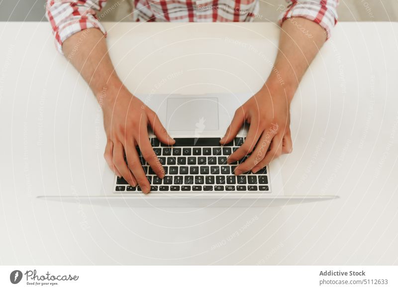 Crop man typing on a Modern Laptop business button close-up closeup computer computing desk equipment finger hand job keyboard keypad laptop occupation office