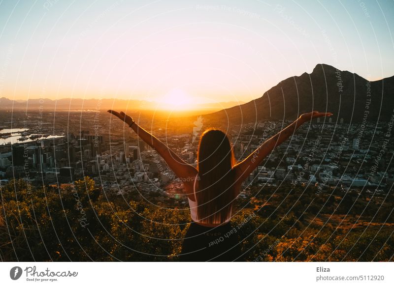 Young woman standing with arms outstretched at sunrise on Signal Hill in Cape Town Sunrise Woman extended arms outstretched arms Freedom in the morning