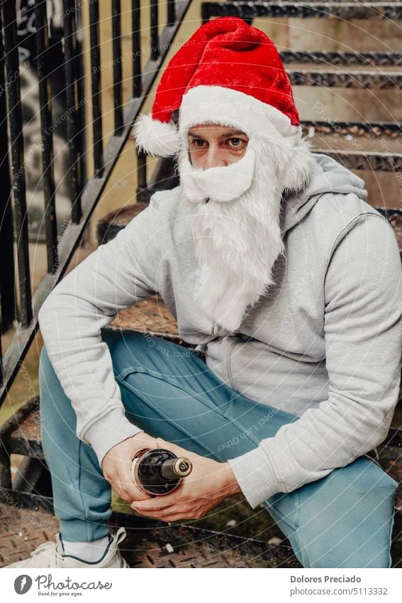 Homeless Santa drinking wine and rummaging through garbage bins alcohol alcoholic bad santa beard begging bottle brutal caucasian celebration charity christmas