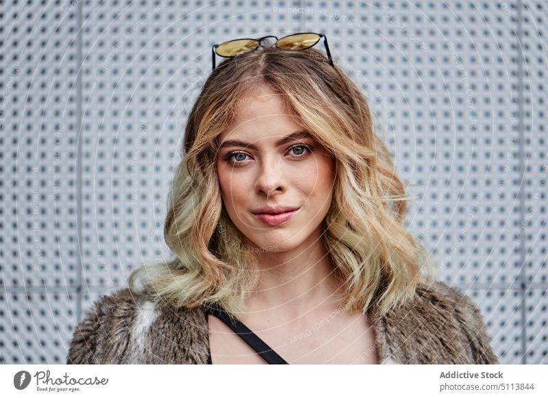 Cool young female model standing on street and looking at camera woman style confident gorgeous self assured personality portrait charismatic individuality