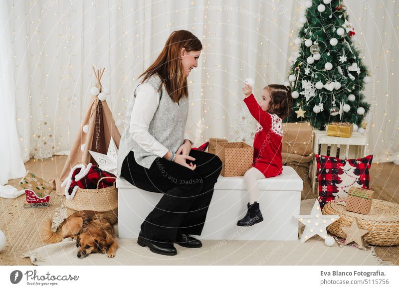 smiling mother and daughter at home enjoying christmas time at home family living room love together motherhood single mother caucasian celebration child happy