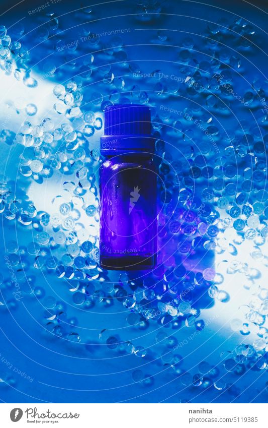 Organic essencial oil in a dark blue bottle against an elegant blue background essential health fresh diamond water still life object product essential oil