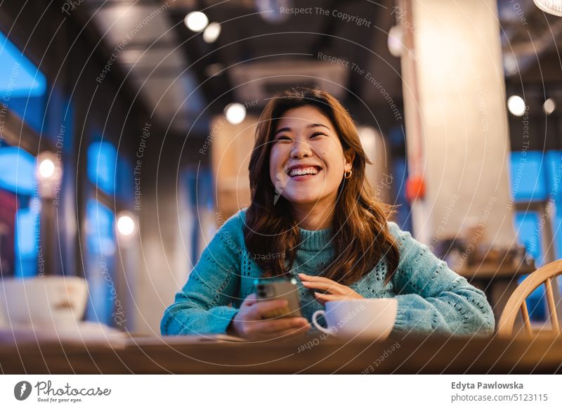 Young woman drinking coffee in cafe real people candid girl young adult fun millennials Millennial Generation asian Japanese happy smiling happiness one person