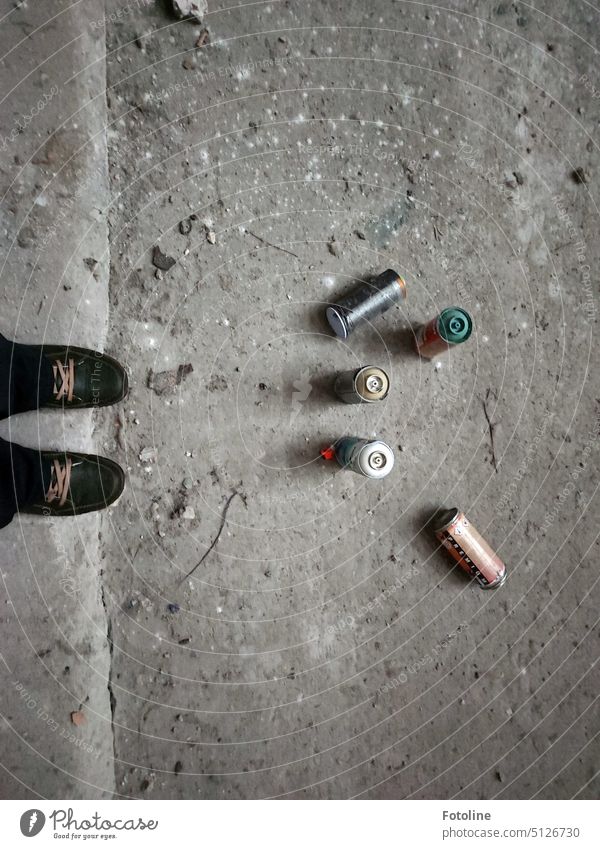 Empty paint cans lie on the gray floor in front of my feet. Somewhere this lost place has become more colorful. Only the garbage should have been taken away again by the artists.