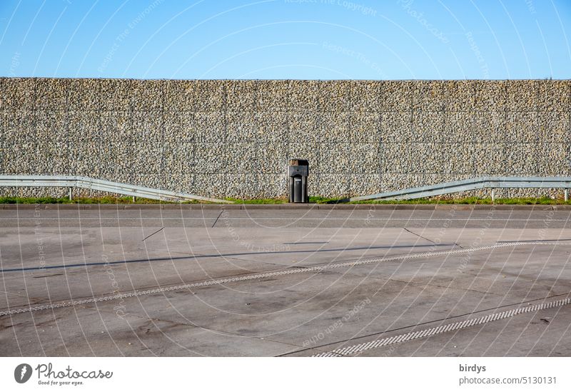 Highway parking lot with sound barrier, crash barriers and garbage can and blue sky. Symetry symmetry Symetric soundproof wall guardrails dustbin Blue sky